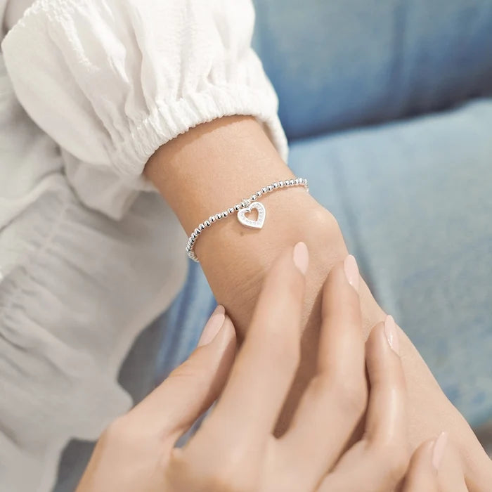 A Littles & Co Be Your Own Kind Of Beautiful bracelet worn on wrist, silver-plated stretch bracelet with heart charm
