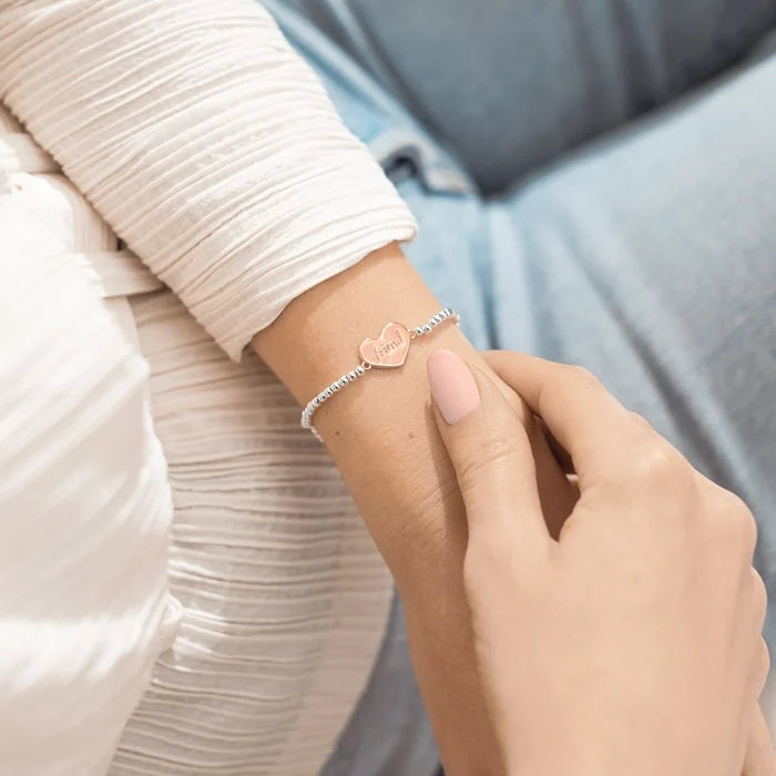 Silver A Littles & Co Friends For Life bracelet worn on wrist featuring heart charm engraved with “friend”