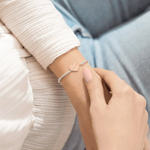 Silver A Littles & Co Friends For Life bracelet worn on wrist featuring heart charm engraved with “friend”
