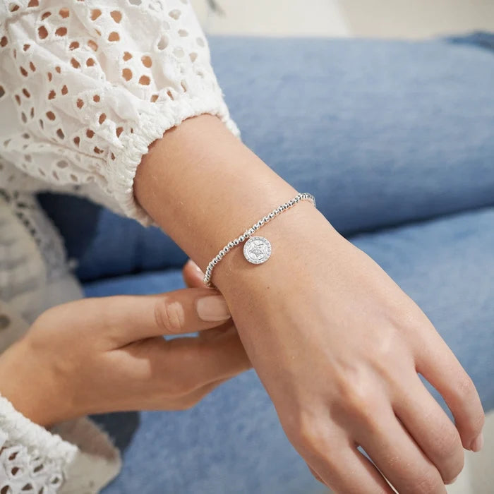 A Littles & Co. A Little Good Luck Bracelet worn on wrist with silver beaded band and star charm