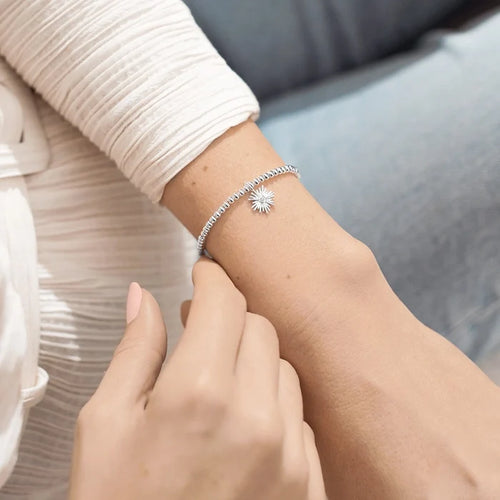 Silver beaded A Littles & Co. Happy Retirement bracelet worn on wrist with sunburst charm