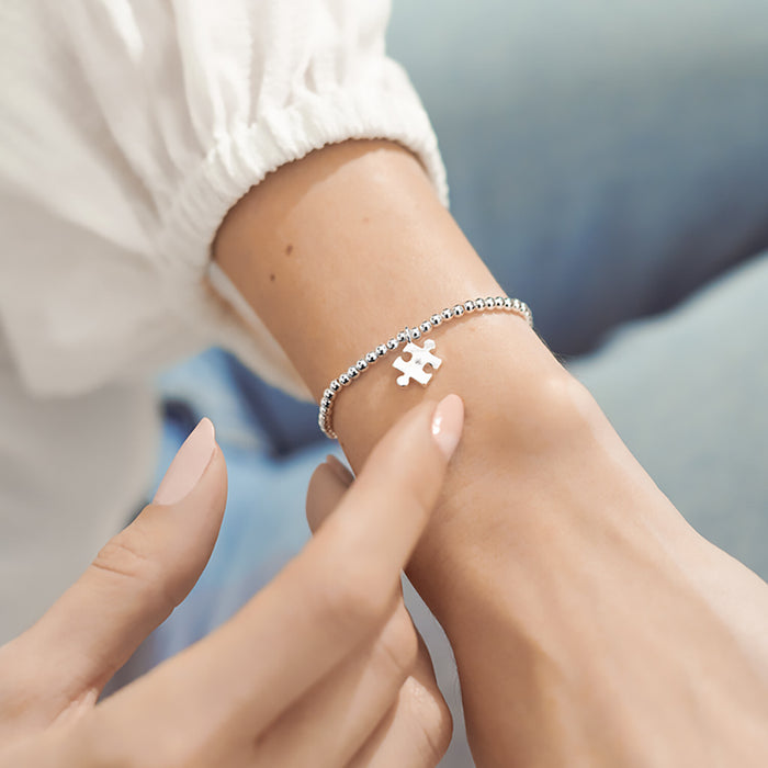 Silver Beaded Bracelet On Wrist, With Silver Puzzle Piece Charm