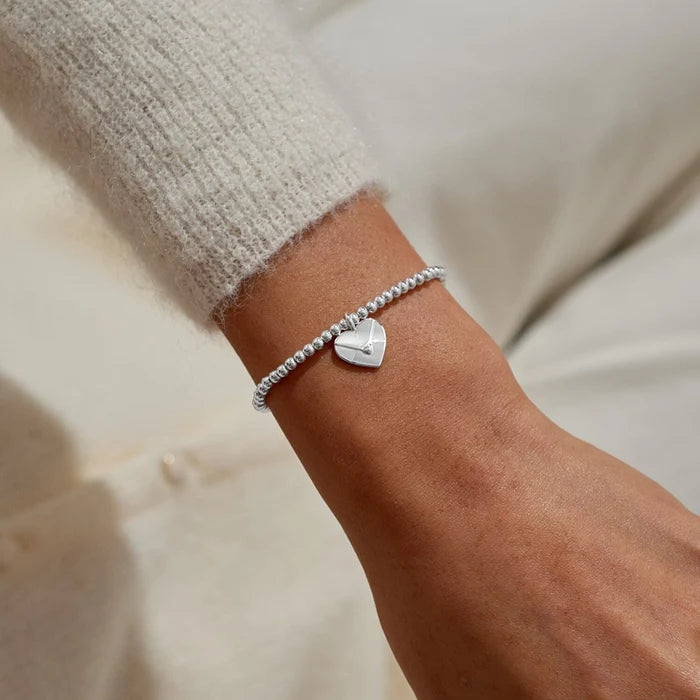A Littles & Co. A Little Sending Love silver heart envelope charm bracelet worn on wrist