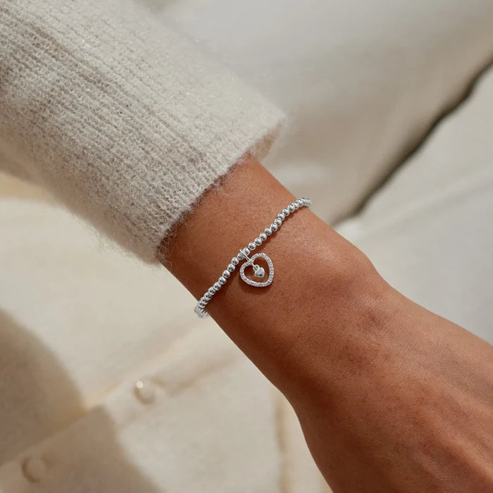 A Littles & Co. So Lucky To Have You silver beaded heart charm bracelet worn on wrist