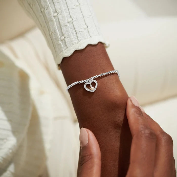 A Littles & Co Special Grandma bracelet worn on wrist, silver beaded stretch bracelet with sparkling heart charm and pearl center