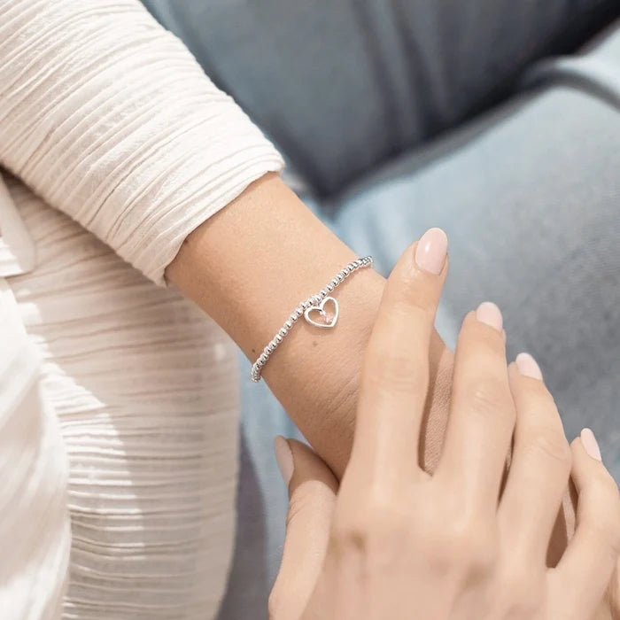A Littles & Co A Little True Friend bracelet worn on wrist featuring silver beaded stretch band and heart charm with crystal detail