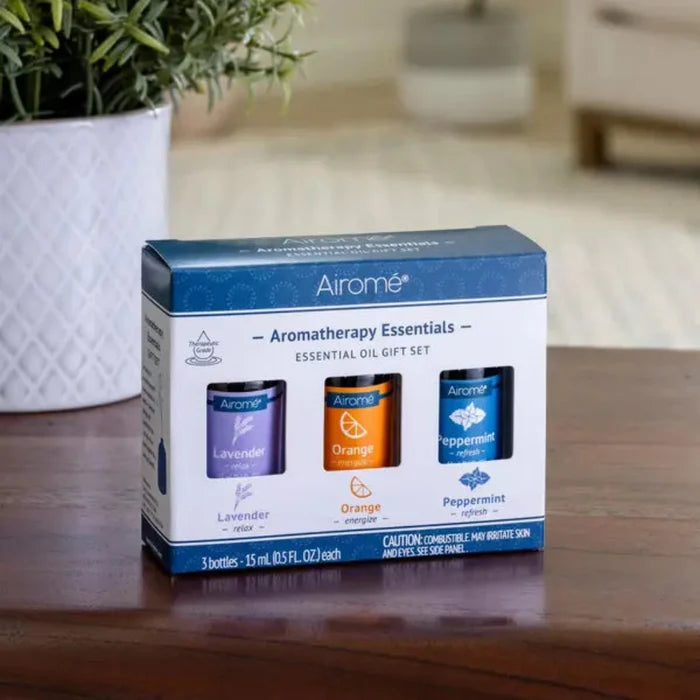 Airome aromatherapy essentials gift set on a wooden surface with a plant in the background