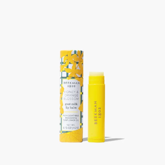 A tube of lip balm featuring a vibrant yellow and green design, showcasing its colorful packaging.