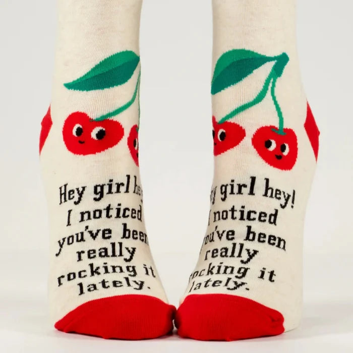 Pair of socks with cherry design and text on a white background