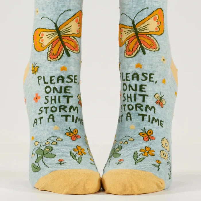 Pair of socks with butterfly design and text on a light blue background