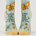 Pair of socks with butterfly design and text on a light blue background