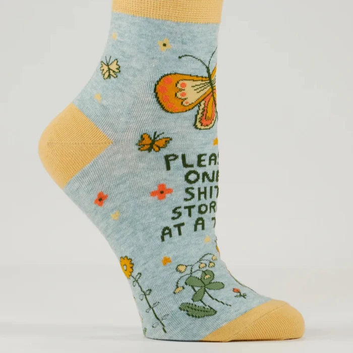 Sock with butterfly design and text on a light gray background