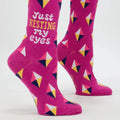 Pink socks with geometric pattern and text 'Just Resting My Eyes' on a white background
