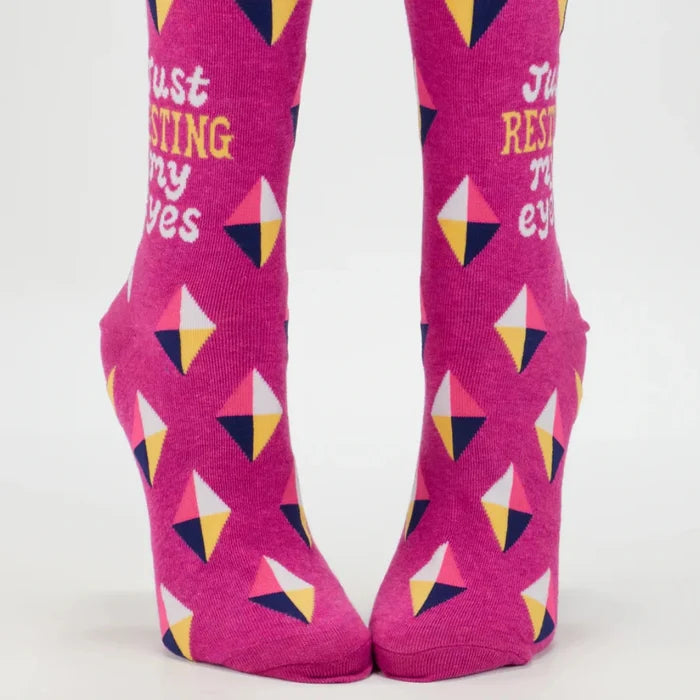 Pink socks with geometric patterns and text on a white background