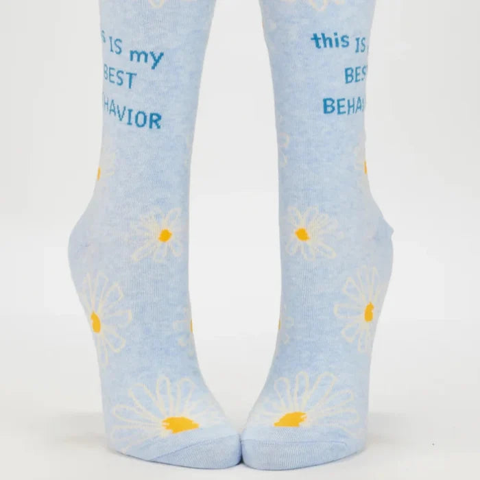 Pair of light blue socks with daisy flowers and text on a white background