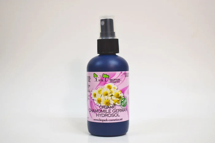 Bottle of organic chamomile German hydrosol with a spray nozzle on a white background