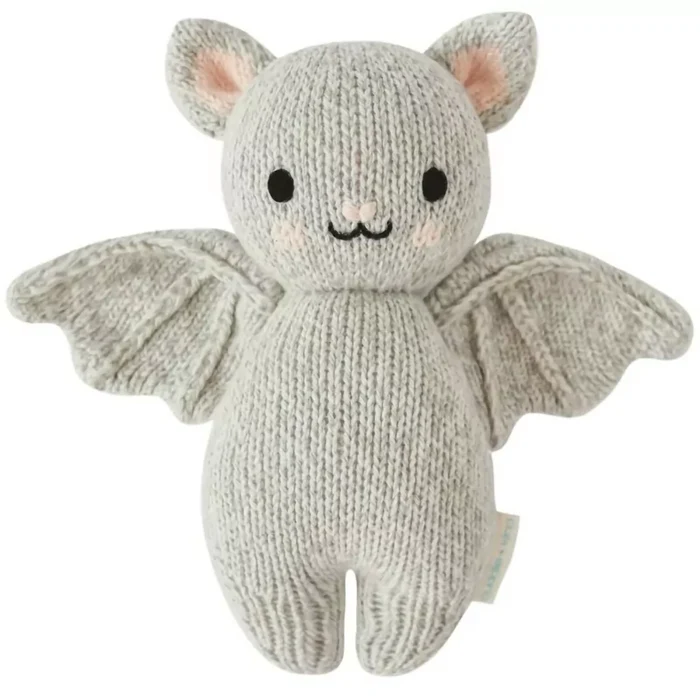 Front view of Cuddle + Kind Baby Bat in Grey – soft handmade knit stuffed bat with cute smile and wings.