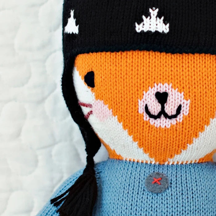 Close-up of Sadie the Fox’s smiling face with black knit hat and blue sweater – Cuddle + Kind fair trade doll