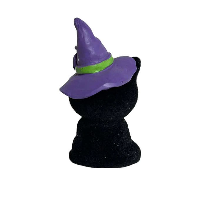 Black cat figurine wearing a purple witch hat on a white background
