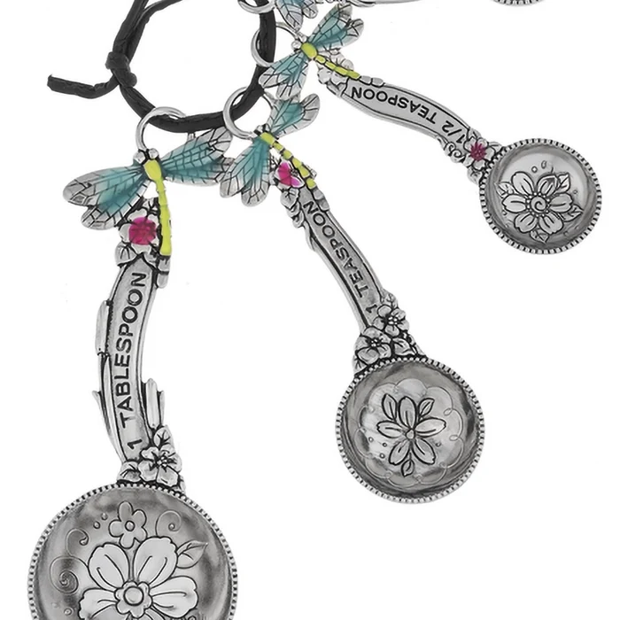 Set of decorative spoons with floral designs and dragonfly charms on a white background