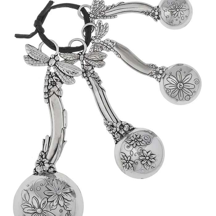 Silver earrings with floral and dragonfly designs on a white background