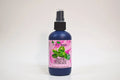 Bottle of organic green tea hydrosol with a pink label on a white background