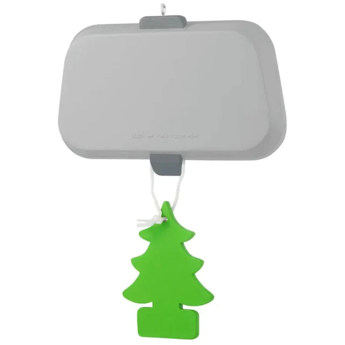 Car air freshener shaped like a green tree hanging from a gray visor clip on a white background