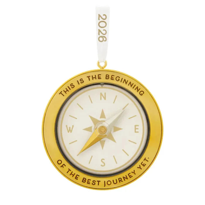 Gold compass ornament with 'This is the beginning of the best journey yet' text on a white background