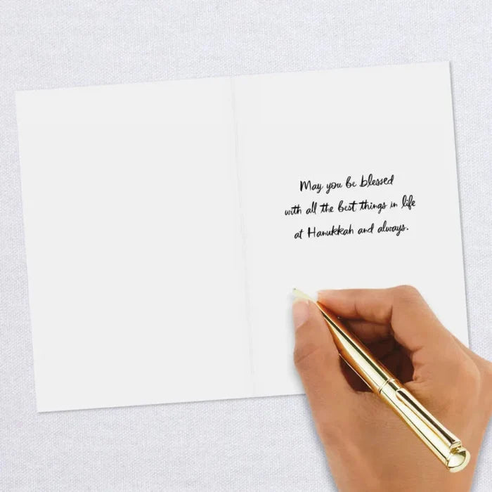Hand holding a gold pen above a white card with a message on a light gray background