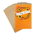 Stack of orange greeting cards with 'Happy Fall' wreath design on a white background.