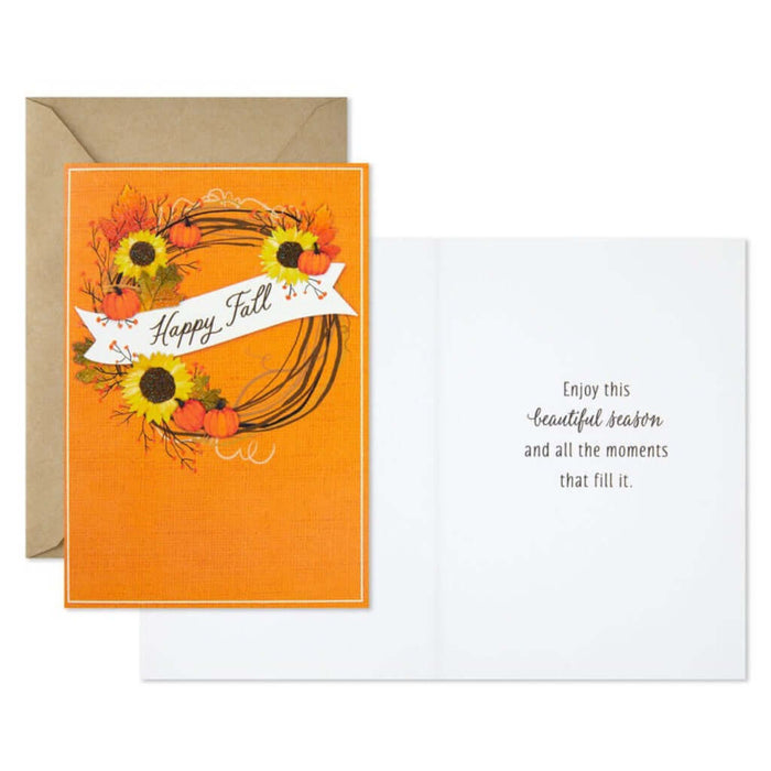 Autumn-themed greeting card with sunflowers, pumpkins, and a wreath on an orange background.