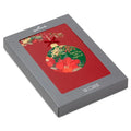 Decorative Christmas ornament with floral design and 'Deck the Halls' text, inside a red and gray box.