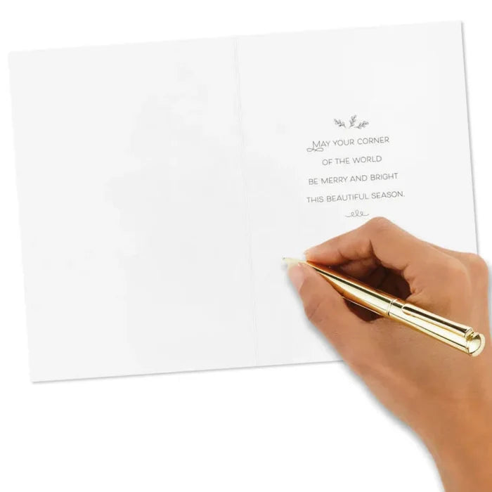 Hand holding a gold pen over a white card with text on a white background