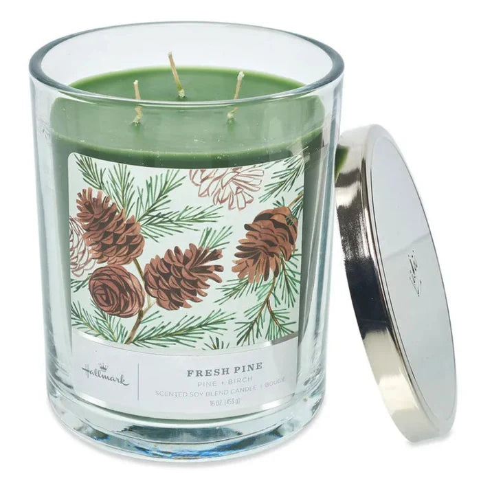 Hallmark 3 wickGlass candle with a pine cone design and silver lid on a white background