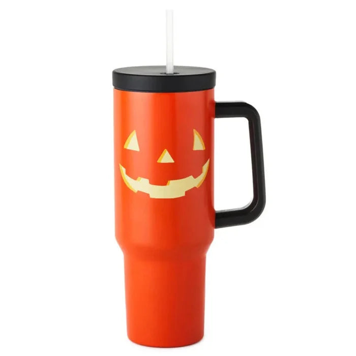 Orange travel mug with a black lid and handle, featuring a jack-o'-lantern face design on a white background.