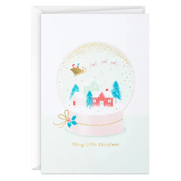 Christmas card with a snow globe design featuring trees and a house, on a white background.