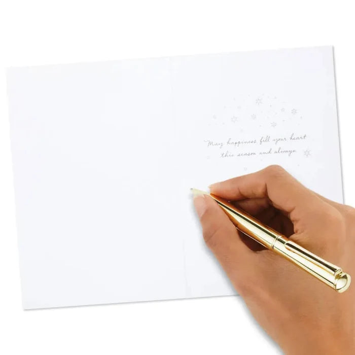 Hand holding a gold pen over a white sheet of paper with text on a white background