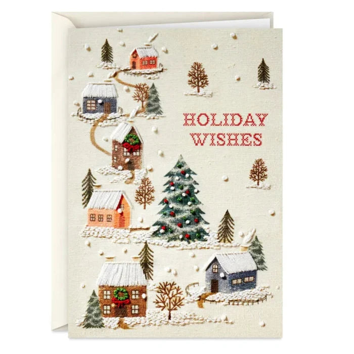 Christmas card with winter village scene, trees, and 'Holiday Wishes' text.