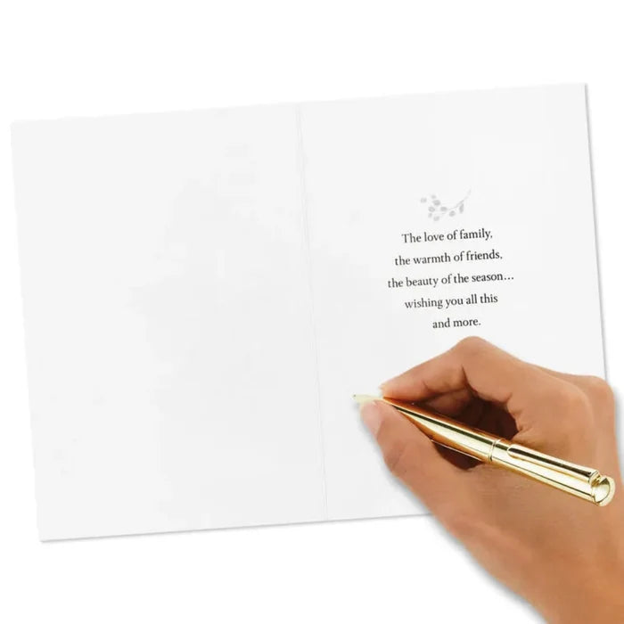 Hand holding a gold pen over a white card with text on a white background