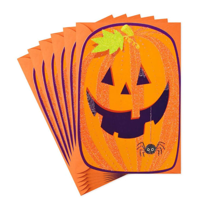 Stack of orange greeting cards with Smiling Jacko lantern pumpkin design on a white background