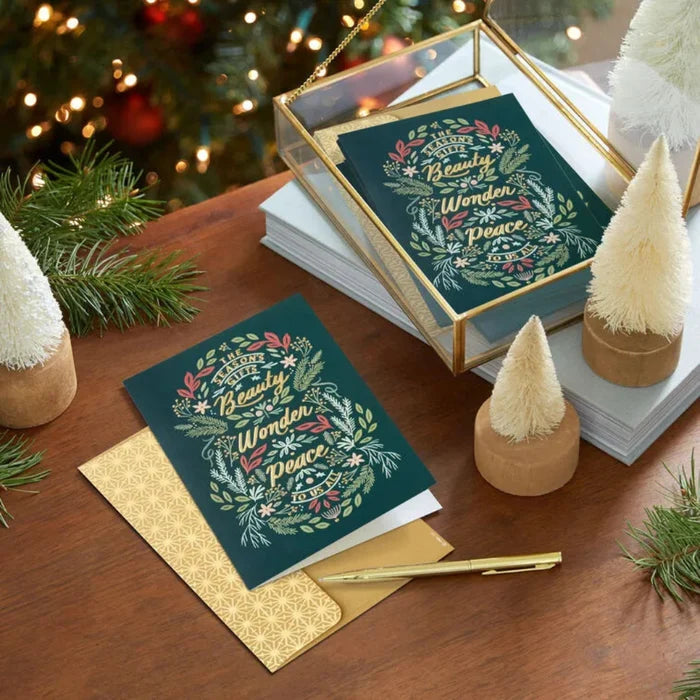 Christmas card with decorative envelope on a festive table setting.