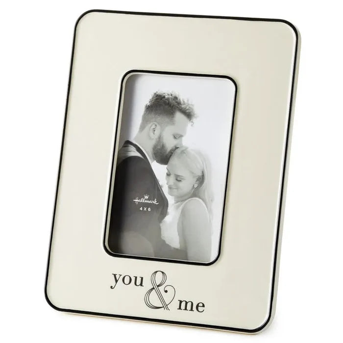 Cream photo frame with 'you & me' engraving holding a black and white photo of a couple.