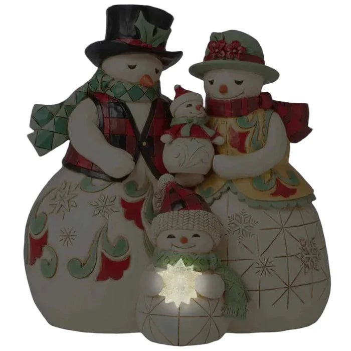 Jim Shore Decorative snowman family figurine with the child snowman holding a light (AAA batteries)  at the base on a white background
