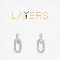 A pair of silver earrings featuring a delicate chain and a loop design, elegantly hanging from the earlobe.