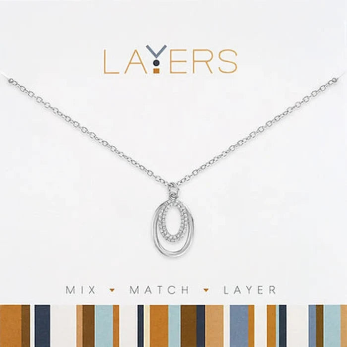 layered necklace featured on a striped backdrop, emphasizing its stylish arrangement and craftsmanship.