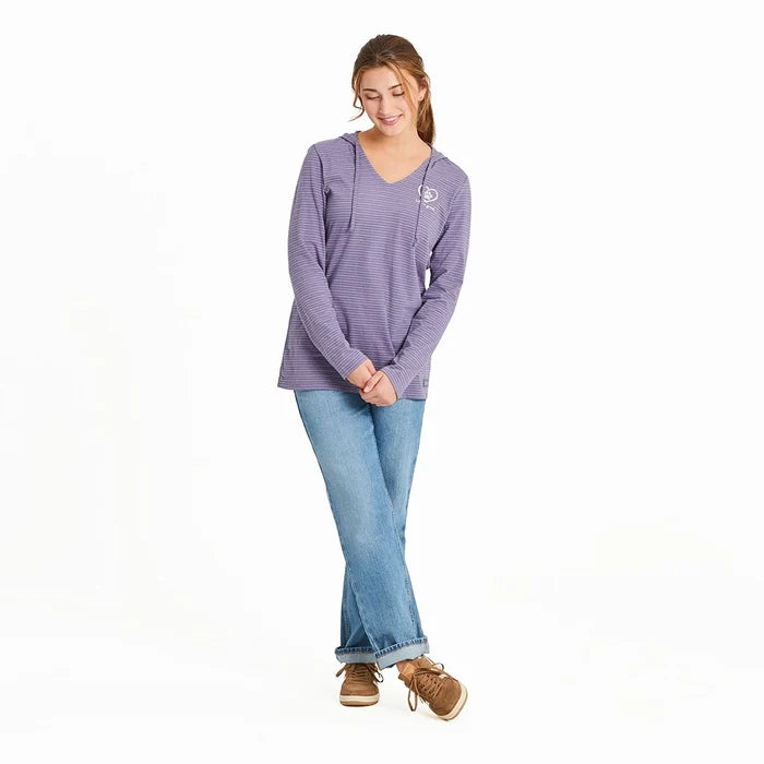 Full-body view of woman wearing Life Is Good Women’s Pet Paw Crusher Hooded Tee in purple stripes, paired with jeans