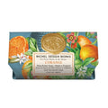 A bar of Michel Design Works L'Orange shea butter soap in floral and orange-themed packaging with a gold seal on the wrapper.