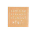 Mud Pie “Adulting Requires Alcohol” cocktail napkins featuring white embossed text and drink illustrations on tan paper.