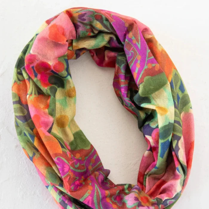 A decorative floral print scarf draped on a wall, displaying a mix of vivid colors and intricate flower designs.