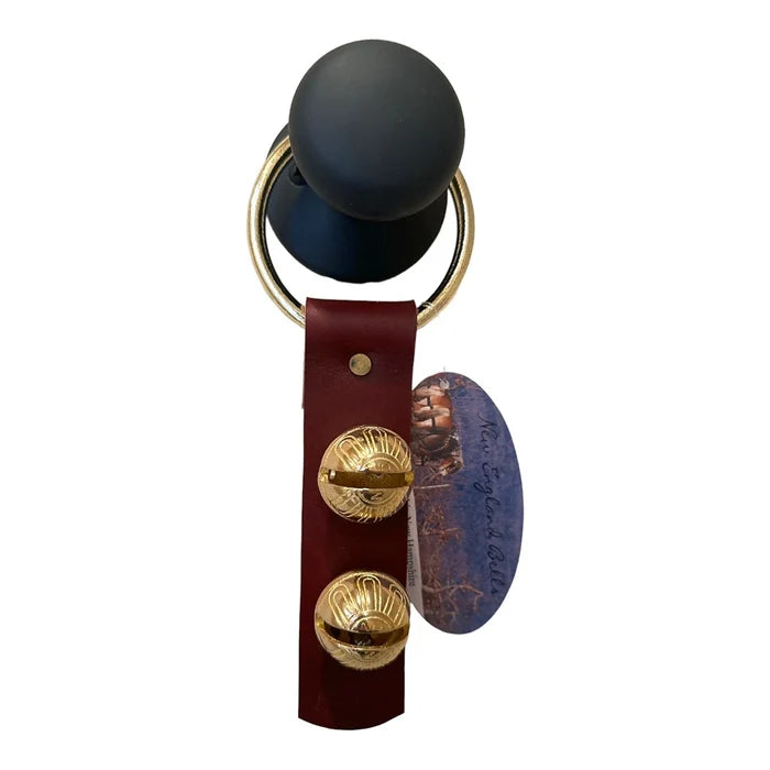 Keychain with black sphere, gold buttons, and leather strap on a white background